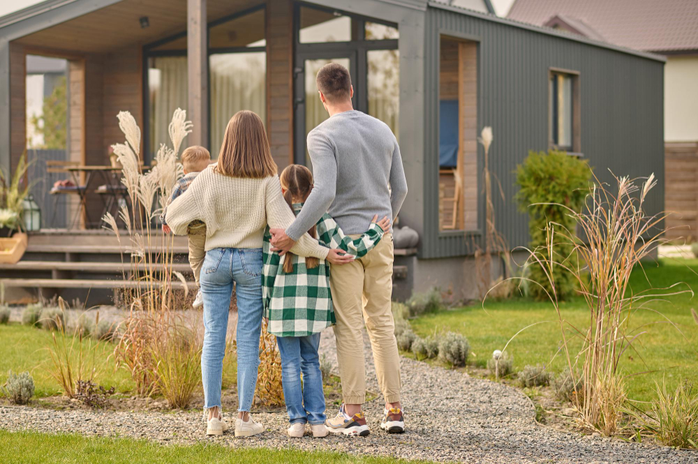 Familie blickt auf die eigenen vier Wände das Eigenheim nach erfolgreicher Baufinanzierung